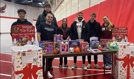 Student athletes smile at toy drive.