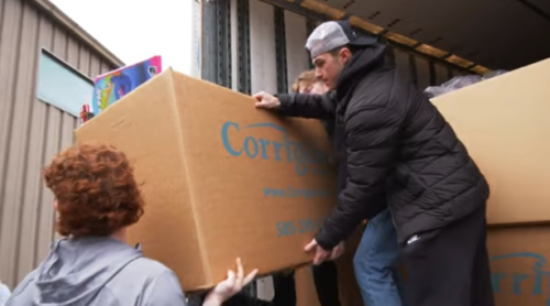 Students lift a box of toys to a truck