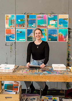 Charlotte Orgill stands in front of her art