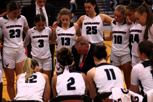 Kevin Clifford speaks to the basketball team during a stoppage of play