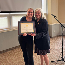 Laura Coles smiles while receiving award