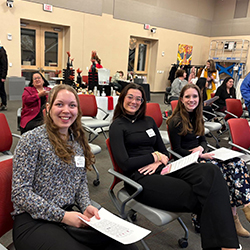 Students sit and smile.