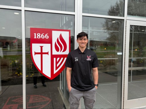 Noah Balaam smiles in front of the Roberts shield