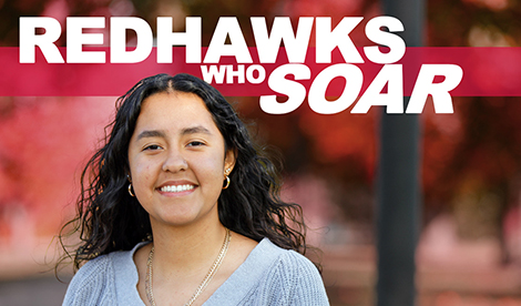 A young woman smiles outside. The words Redhawks Who Soar overlays