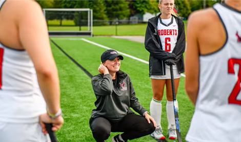 Coach Kocher crouches while speaking to team