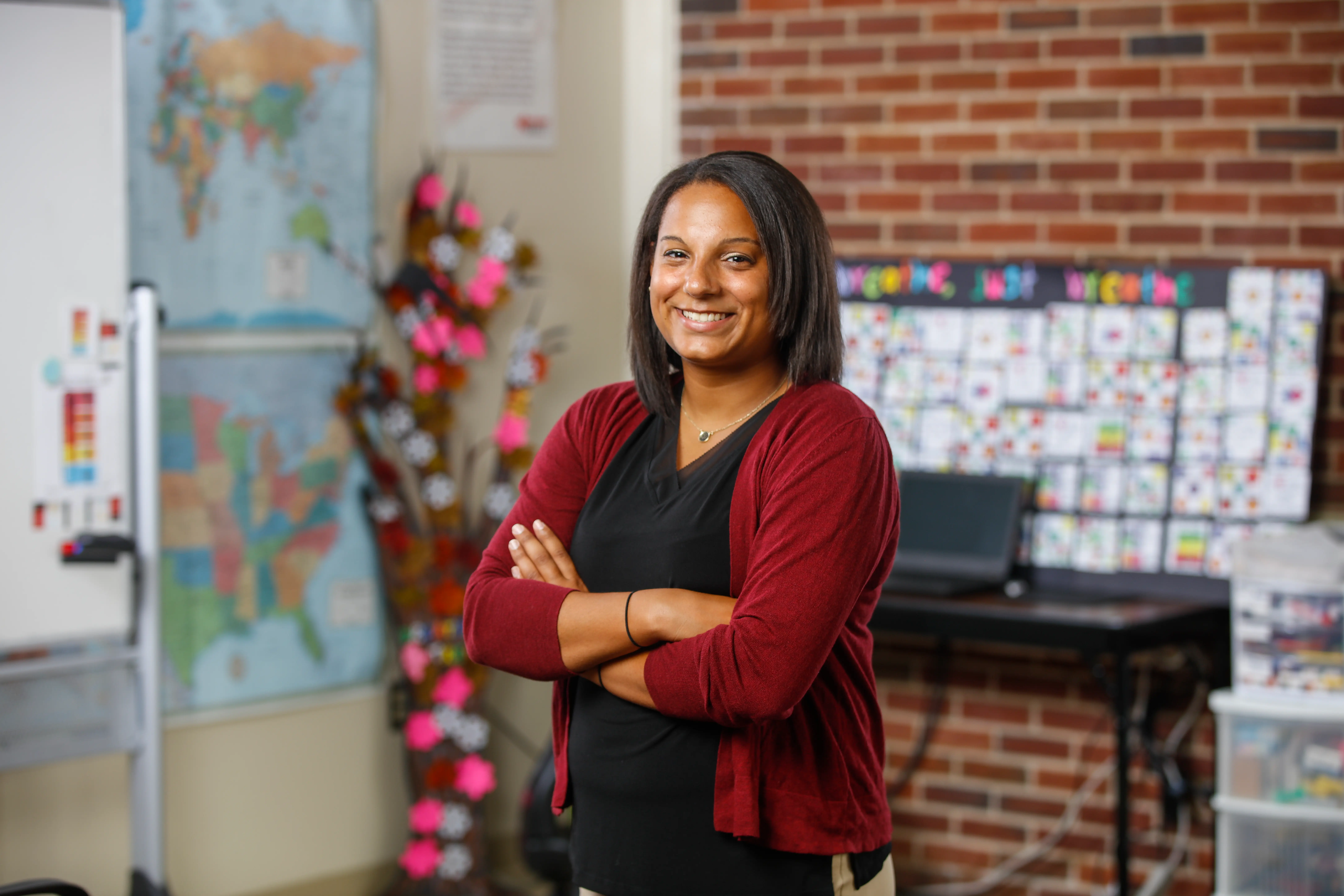 A teacher crosses her arms and smiles