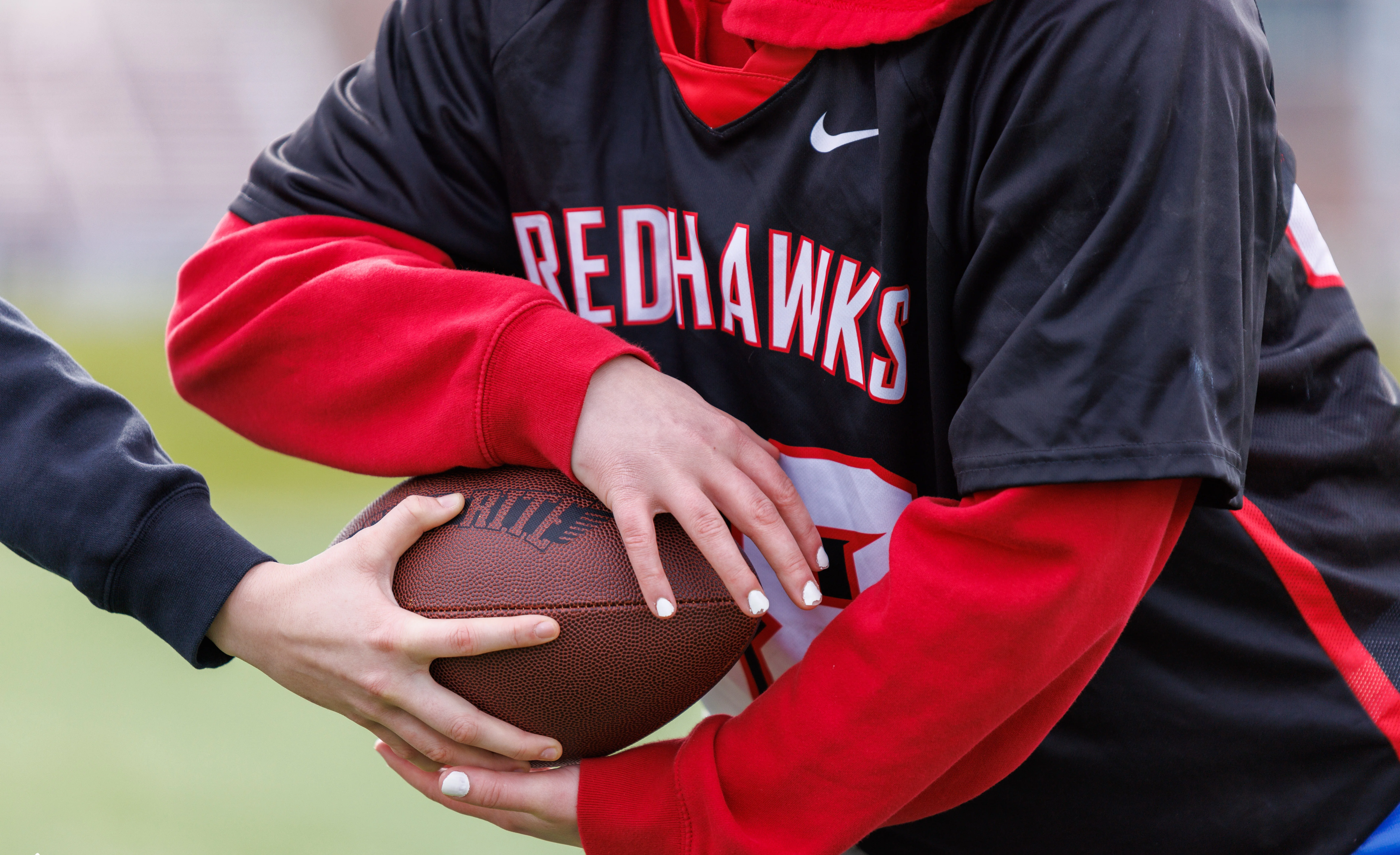 A female student grabbing a football