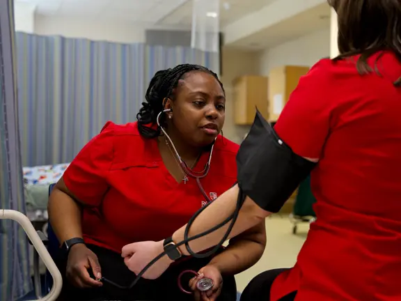 Nursing students taking blood pressure
