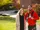 A young man and woman stand on campus and smile
